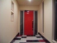 玄関ドアは光沢のある赤を選択しました。
床は白と黒の市松模様で、ところどころに赤をアクセントとして入れています。
側面から、光が差し込むので、とても明るい玄関です。